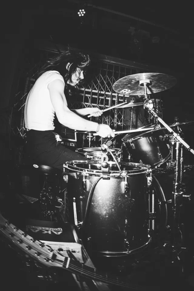 Batteur derrière sa batterie en concert, photo noir et blanc