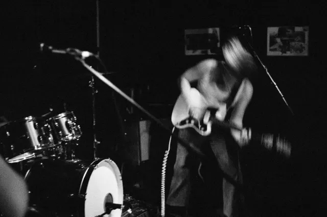 Guitariste au micro sur scène, photo noir et blanc
